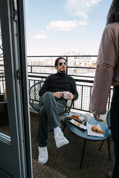 Man drinking coffee on balcony