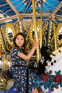 Film portrait of young girl riding on a carousel horse