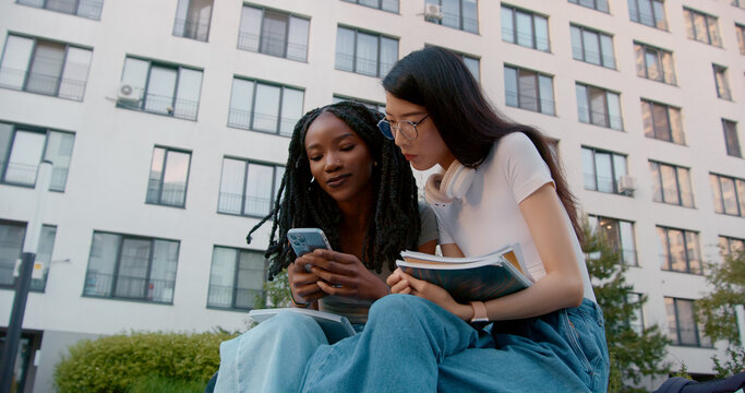 Two students sharing information outdoors 