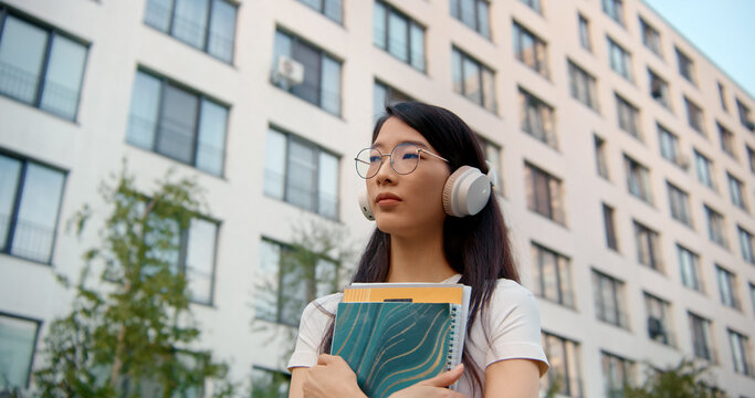 Young student wearing headphones listening to music 