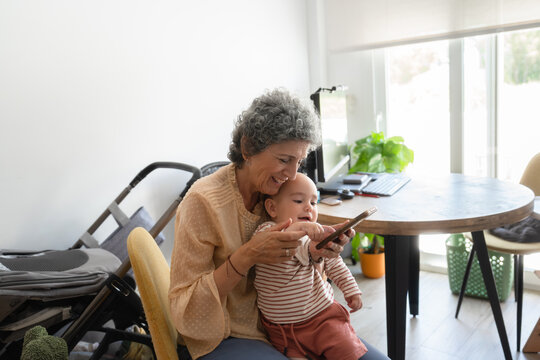 Grandmother and grandchild using smartphone at home