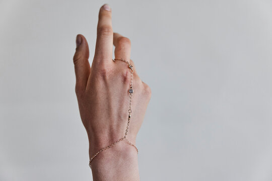 Hand with golden hand chain bracelet