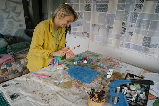 Artist with paints in workshop