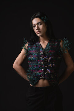 Androgynous person with colorful vest and dried flowers 