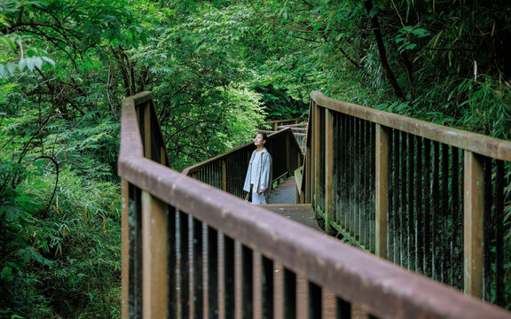 A woman experiencing the beauty of nature on a forest trail.