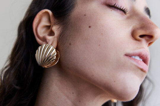Young model with a seashell golden earring