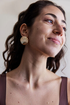 Young model with a seashell golden earring