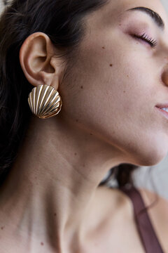 Young model with a seashell golden earring