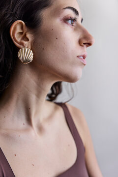 Young model with a seashell golden earring