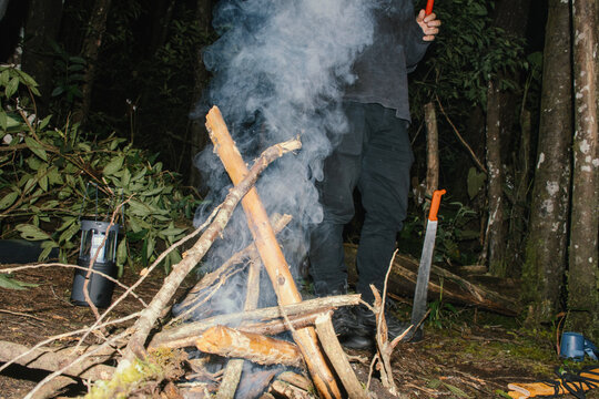 Campfire building in the woods during late evening hours