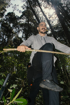 Man navigating through dense forest during daylight exploration
