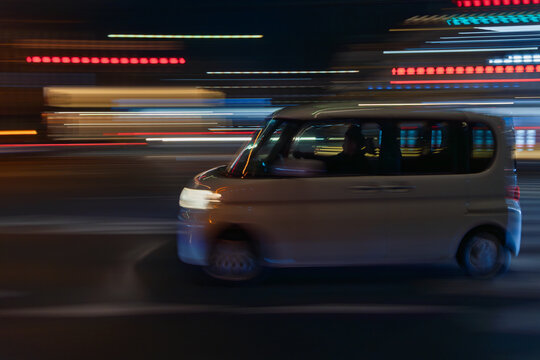 夜の流し撮りの白い乗用車