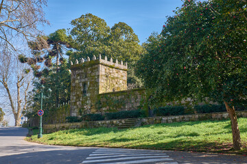 Historic wall with a granite tower surrounded by lush vegetation in Castrelos Park © Uvamenfoto