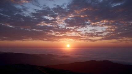 Fototapeta premium Breathtaking sunrise or sunset with a golden glow over a misty fog covered mountain landscape from an elevated viewpoint
