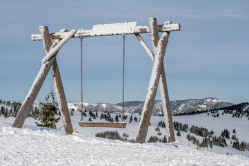 Wooden swing covered in snow on top of Nova Hola in Nizke Tatry near Donovaly Slovakia © Stefan