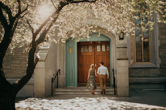 Couple walking into church doorway on Easter morning, spring faith tradition, sacred celebration and spiritual holiday moment.