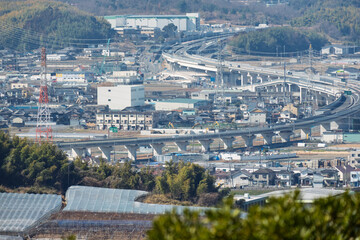Anime style landscape of a Japanese suburban town with expressway and residential area in winter
