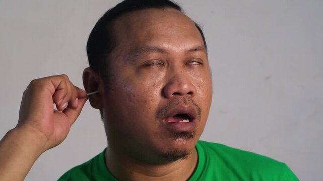 A man cleans his ears, clean his ears with a cotton swab