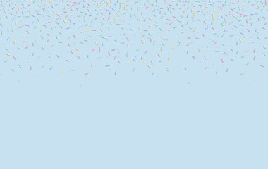 Soft pastel confetti sprinkles scattered on light blue background with copy space