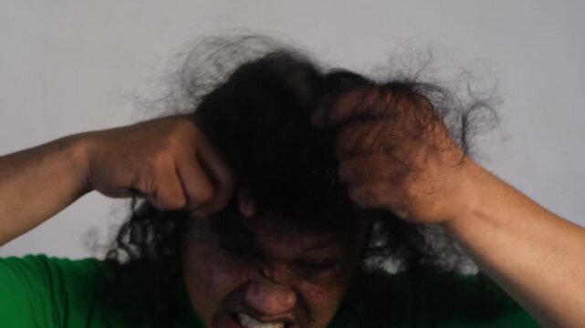 A man combing his hair has problems with hair loss, dryness, dullness, split ends, and damage.