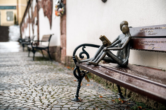 Small sculpture of couple reading on bench in historic center of Banska Stiavnica Slovakia