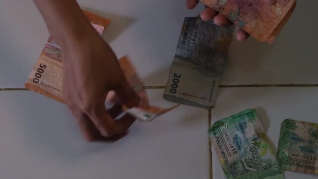counting the money, hands holding Indonesian rupiah banknotes and start counting, isolated on white background