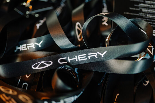 Chery branded lanyards displayed on a table during a promotional event showcasing Chery TIGGO models and accessories