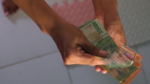 counting the money, hands holding Indonesian rupiah banknotes and start counting, isolated on white background