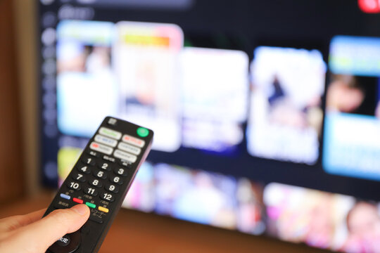 テレビに向けたリモコン操作 動画配信サービス視聴イメージ
