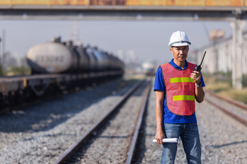 Railway Technician Communicating by Radio at Freight Rail Yard