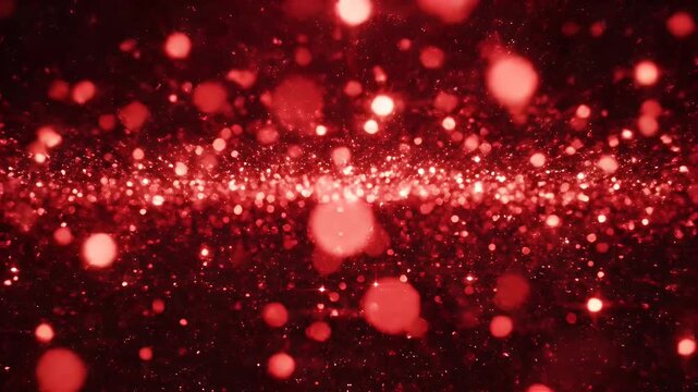 Abstract, out-of-focus image with red glitter particles, bokeh, and a dark background