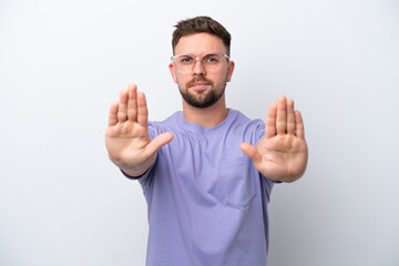 Naklejka premium Young caucasian man isolated on white background making stop gesture and disappointed