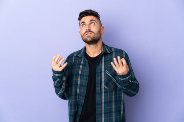 Fototapeta premium Caucasian man isolated on purple background stressed overwhelmed