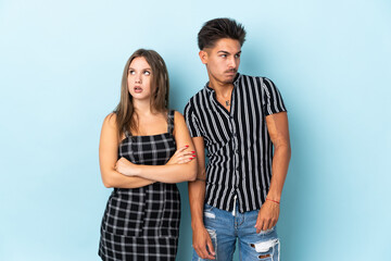 Fototapeta premium Teenager caucasian couple isolated on blue background with confuse face expression while bites lip