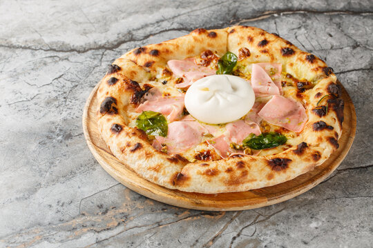 Oven-baked pizza with burrata and mortadella sausage close-up on a wooden board