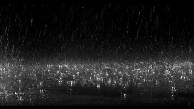 Realistic rain drops hitting the ground creating beautiful water splashes on a dark black background. Perfect cinematic rain overlay for video editing, visual effects, films, trailers, music videos