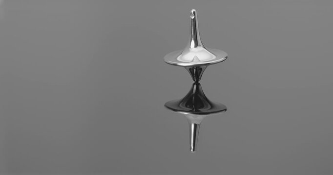 Metallic totem in initial steady rotation, gradually increasing wobble and tilt toward collapse against a deep mirrored backdrop.