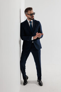 Confident man rubbing hands and looking to side