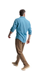 Casual young man walking and looking away