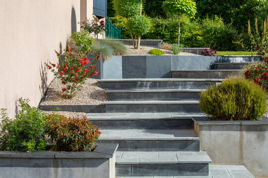 Charmant petit jardin paysag&eacute; et ses plantes au milieu des all&eacute;es et des murets.