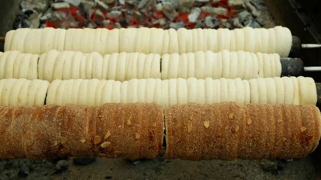 Czech trdelnik trdlo trozkol hungarian cinnamon chimney cake street Christmas stall market food topped with sugar and walnut mix dough. Pastry baking cooking grill outdoor fresh sweet dessert