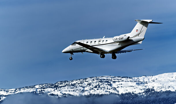 Geneva, Switzerland - february 13, 2026 : signs and logotype on a Pilatus PC-24 of Jetfly Aviation landing at Geneva airport with Snow-covered Jura mountains