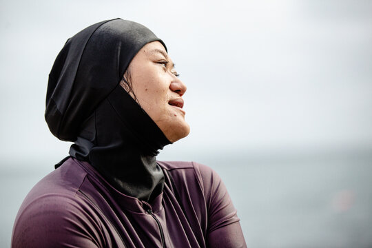 Close up of Hmong-American wearing black headscarf looking away