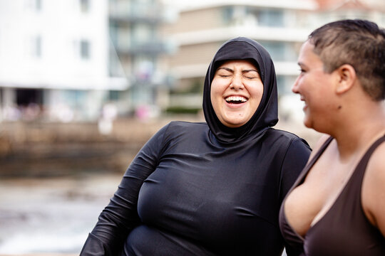 Close up of Italian-Filipino woman having a conversation with French Islander woman in tidal pool