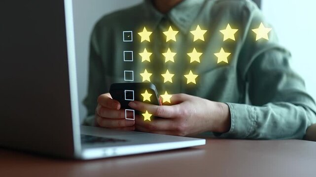 User gives feedback on a service using a phone while sitting at a desk with a laptop in an indoor location.