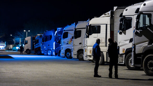 Saint-Martin-de-Crau, Arles area, France, 18 February 2026: two truck drivers talking together during a night stop in a parking area