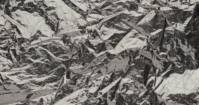 Stop-Motion Crumpled Foil Texture. Rapid stop-motion animation featuring quick successive frame changes of heavily wrinkled aluminum foil surfaces.