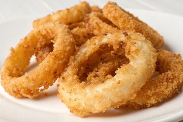 Crispy golden fried onion rings served on a white plate