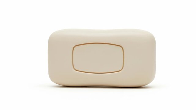 A small, beige, rectangular object with rounded edges and a recessed square on its front
