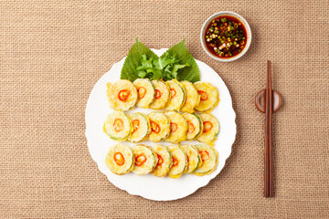 호박전 얇게 썬 애호박에 소금을 조금 뿌려서 두었다가 밀가루를 묻히고 달걀 푼 것을 씌워 부친 전

Pumpkin pancakes: Thinly sliced ​​zucchini sprinkled with a little salt, then coated in flour, covered in beaten egg, and fried.
